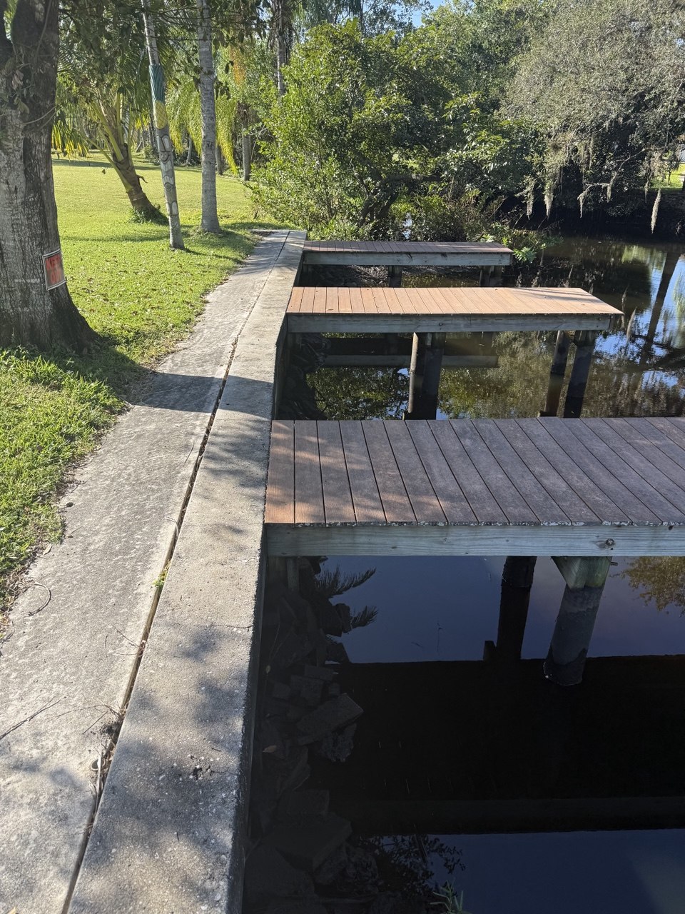 Canal seawall with concrete debris visible at the waterline